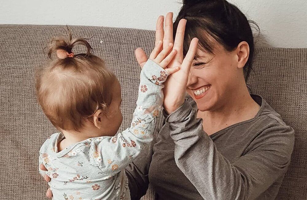 Julia mit ihrer Tochter als Baby. Sie lächeln sich an