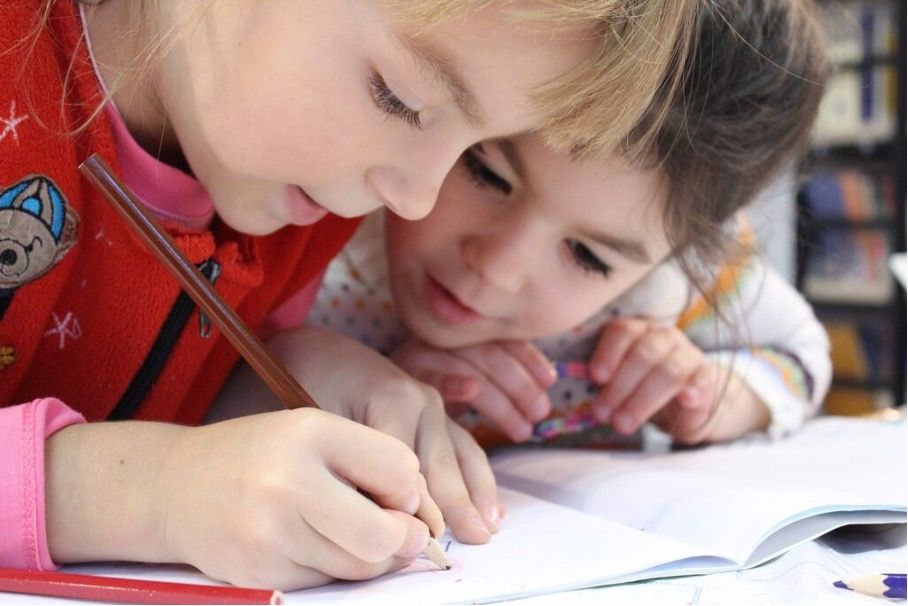 Zwei Mädchen über eine Schulheft
